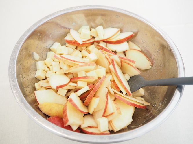 さつまいもとりんごをボウルに入れ、甘煮用のきび砂糖を加え混ざ合わせる。