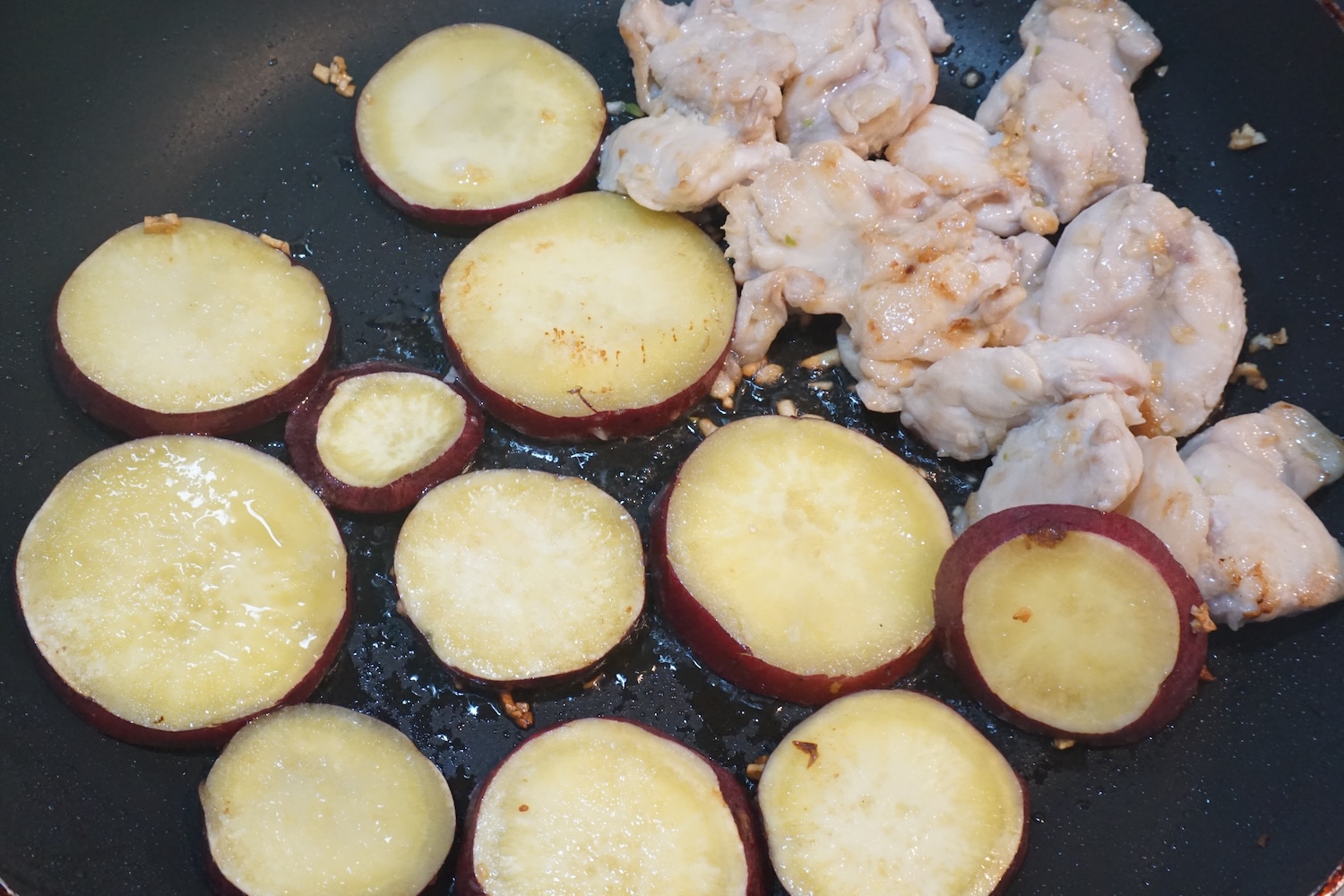 鶏もも肉を加えて炒め、鶏もも肉の色が変わったら端に寄せ、さつまいもを加えてさらに炒めます。