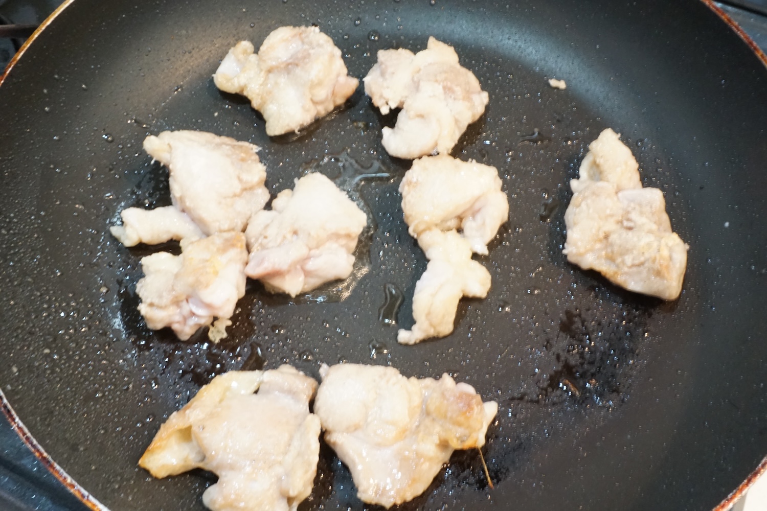 ライパンにサラダ油を入れて広げ、鶏もも肉を並べて火をつける。中火で両面焼き色がつくまでじっくり焼いて火を通す。